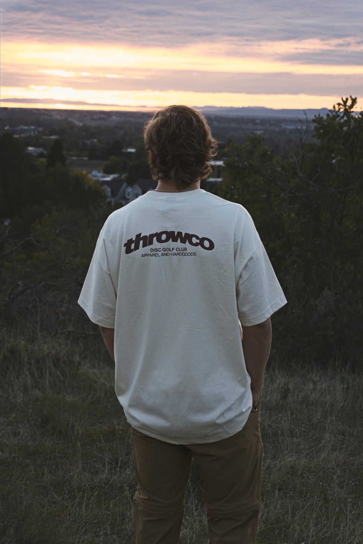 The Classic Throw Co. Tee in Off White, throwco back print, at sunset
